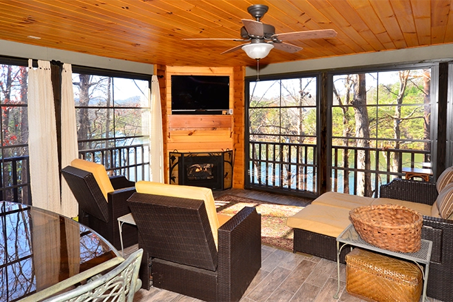 Light brown enclosed porch with television fireplace and furniture