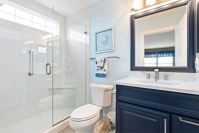 https://www.gehmanremodeling.com/wp-content/uploads/2025/01/Beautiful-smaller-bathroom-remodel-with-glass-door-walk-in-shower-and-blue-vanity.webp?utm_source=chatgpt.com